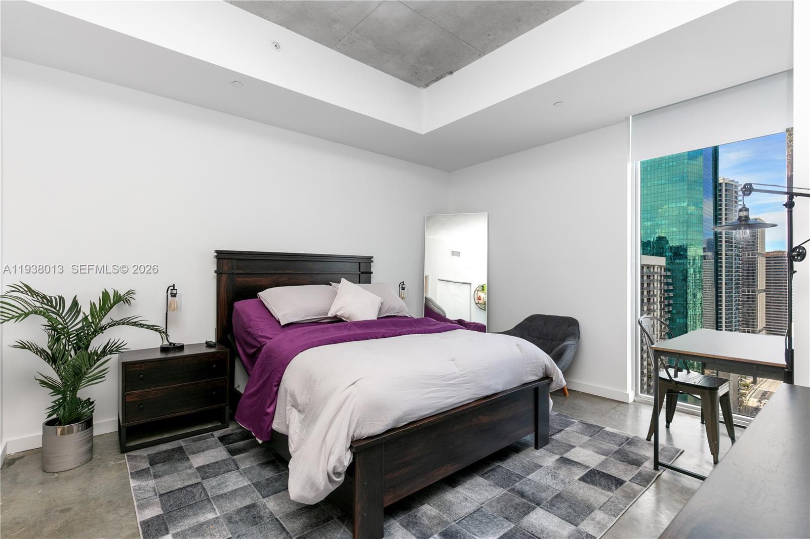 151 Southeast 1st Street, Unit 3103 Miami, FL 33131 - Photo 17 of 51 a bedroom with a bed table flowerpot and a window