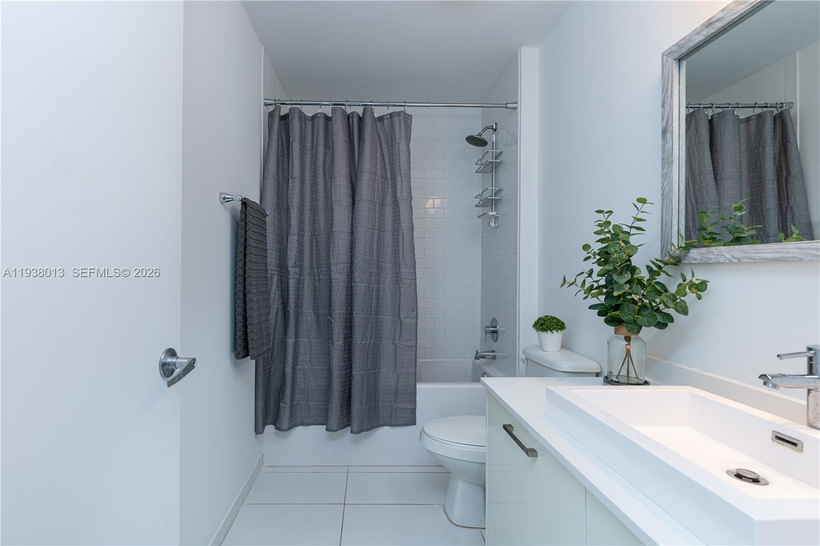 151 Southeast 1st Street, Unit 3103 Miami, FL 33131 - Photo 25 of 51 a bathroom with a sink a toilet a mirror and shower