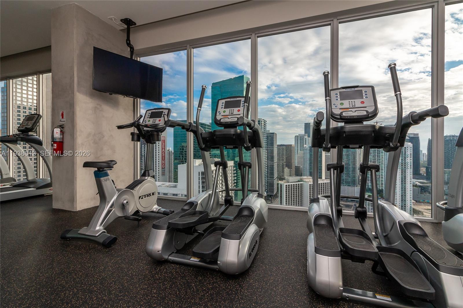 151 Southeast 1st Street, Unit 3103 Miami, FL 33131 - Photo 40 of 51 a room with gym equipment and a large window
