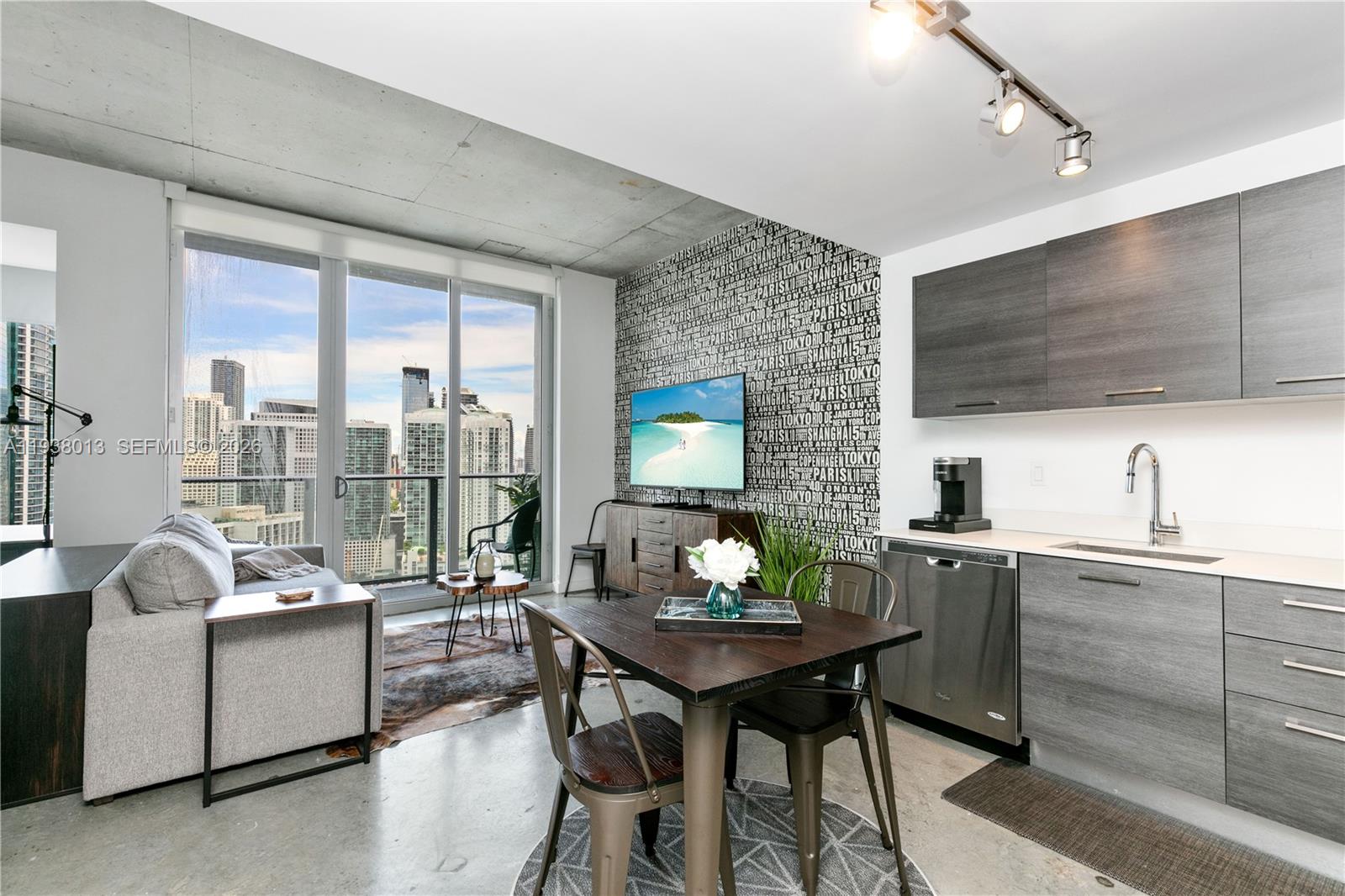 151 Southeast 1st Street, Unit 3103 Miami, FL 33131 - Photo 9 of 51 a living room with furniture a flat screen tv and a floor to ceiling window