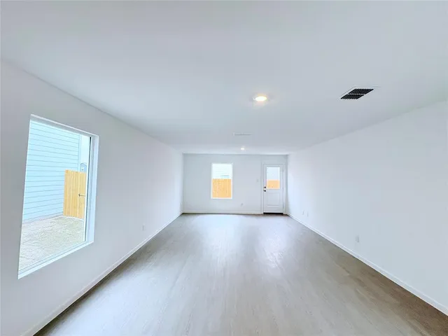 an empty room with wooden floor and a window