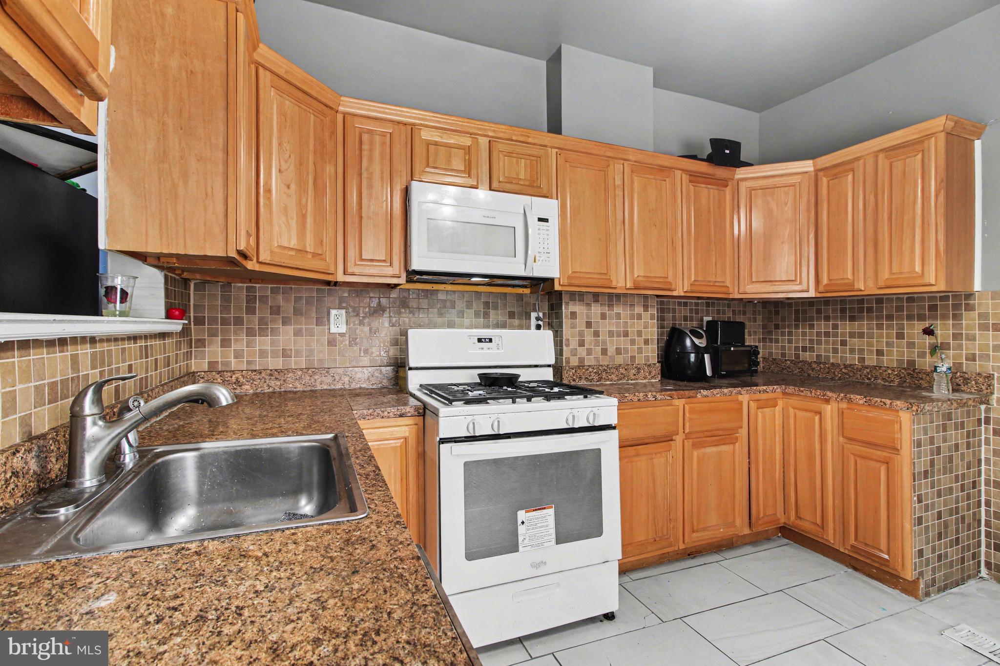 14 South Ruby Street Philadelphia, PA 19139 - Photo 10 of 28 a kitchen with stainless steel appliances granite countertop a sink stove and refrigerator