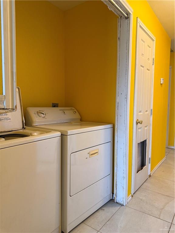 307 Hawaii Street Alton, TX 78573 - Photo 12 of 17 Laundry area featuring a washer and dryer unit, bright yellow walls, and a tiled floor