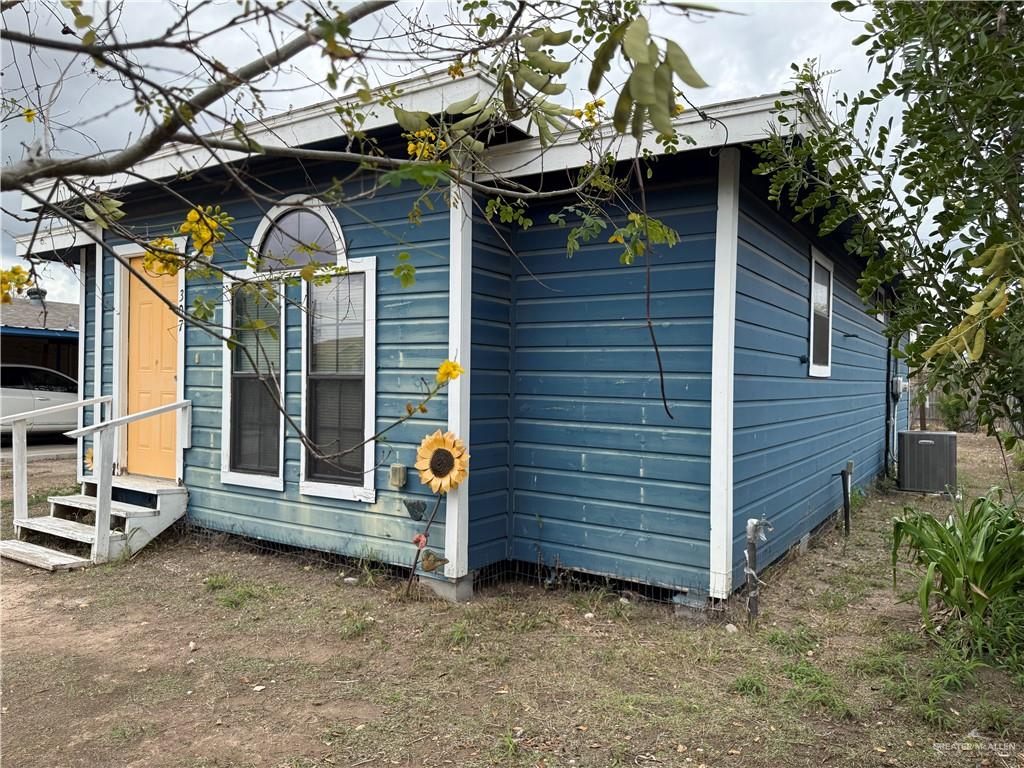 307 Hawaii Street Alton, TX 78573 - Photo 17 of 17 The property features a blue exterior with white trim and a contrasting yellow door