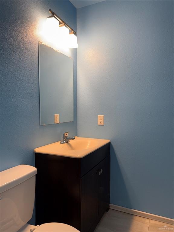 307 Hawaii Street Alton, TX 78573 - Photo 4 of 17 The bathroom features a vanity with an integrated sink and base cabinet storage, a wall-mounted mirror, and overhead lighting