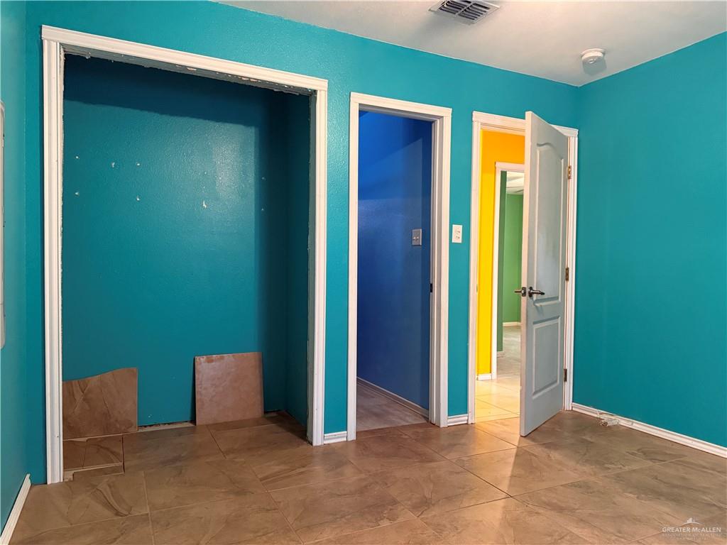 307 Hawaii Street Alton, TX 78573 - Photo 5 of 17 This room features tiled flooring, vibrant teal walls, and white trim