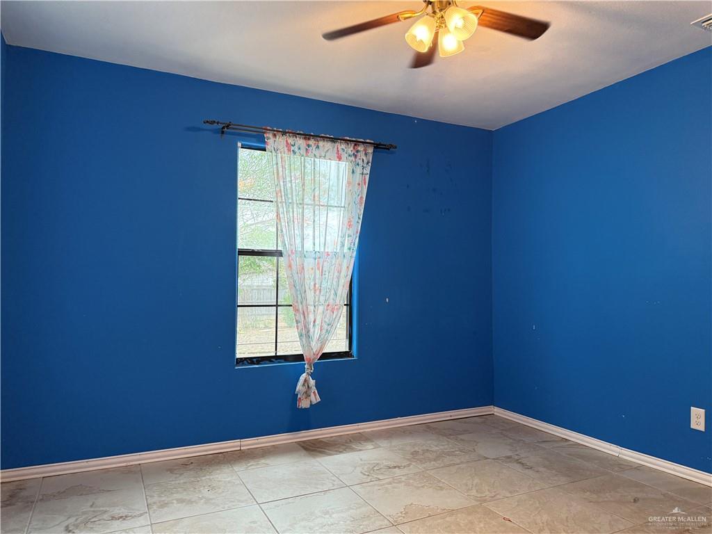 307 Hawaii Street Alton, TX 78573 - Photo 6 of 17 This room features a ceiling fan with integrated lighting, a window, and tile flooring