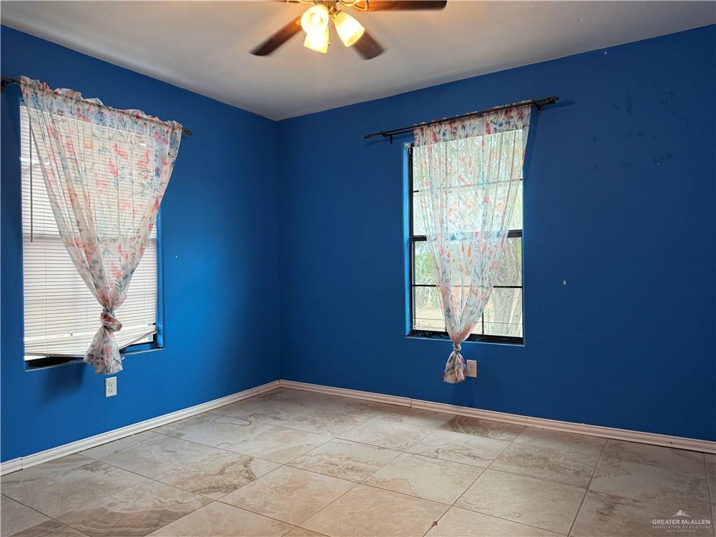 307 Hawaii Street Alton, TX 78573 - Photo 8 of 17 Room featuring two windows, a ceiling fan, and tiled flooring
