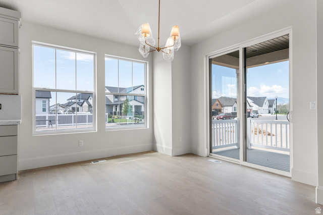 11718 South Halls Crk Road Draper, UT 84020 - Photo 15 of 28 Unfurnished dining area with a residential view, light wood-type flooring, a chandelier, and plenty of natural light
