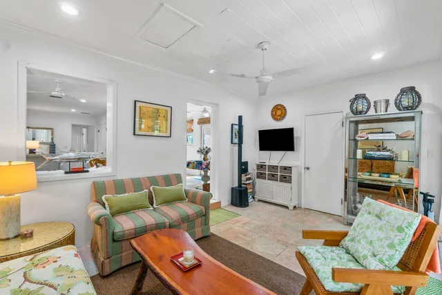 a living room with furniture kitchen view and a flat screen tv