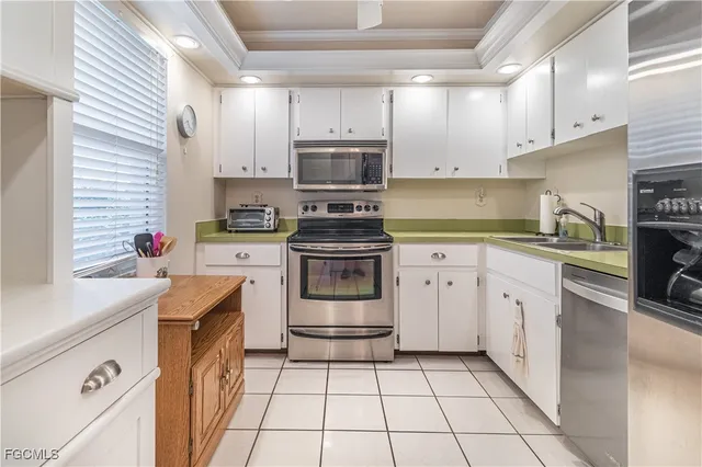 a kitchen with cabinets stainless steel appliances and sink