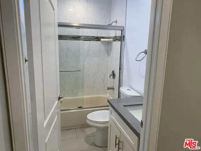 a bathroom with a granite countertop toilet a sink and a bathtub