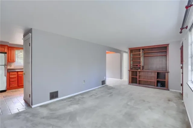 an empty room with furniture and a flat screen tv