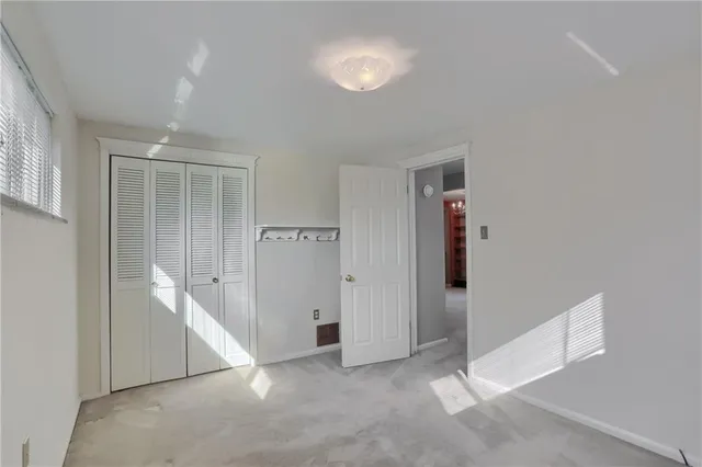 an empty room with closet and windows