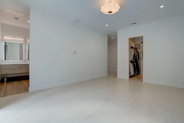 an empty room with a hallway and wooden floor