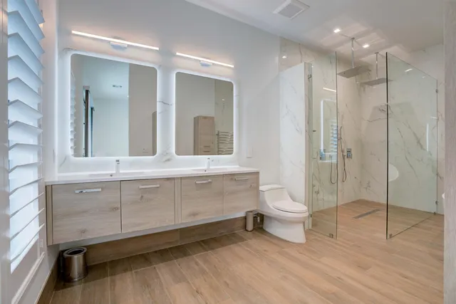 a bathroom with a double vanity sink toilet and shower