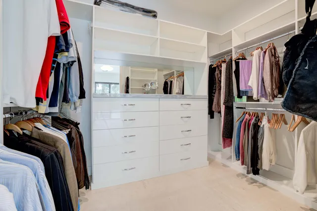 a view of walk in closet with clothes and shoes