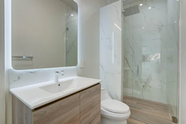 a bathroom with a sink toilet a mirror and shower