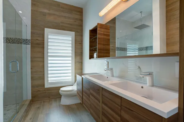 a bathroom with a double vanity sink mirror and toilet