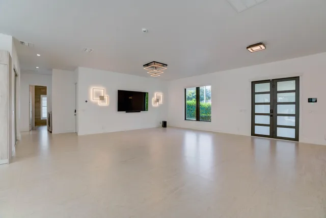 a view of an empty room with window and wooden floor
