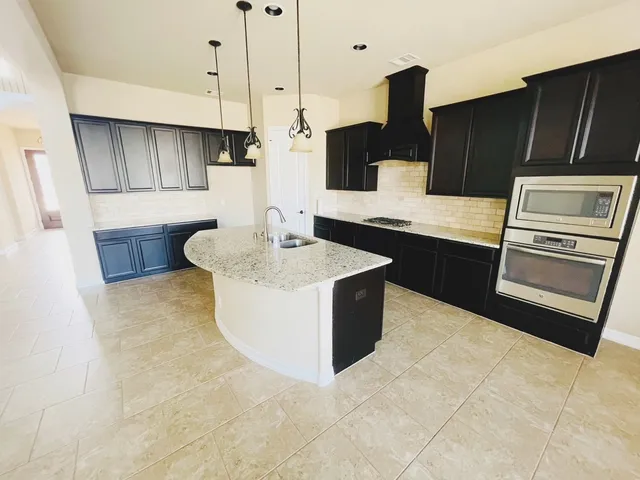 a kitchen with stainless steel appliances granite countertop a sink counter space and cabinets