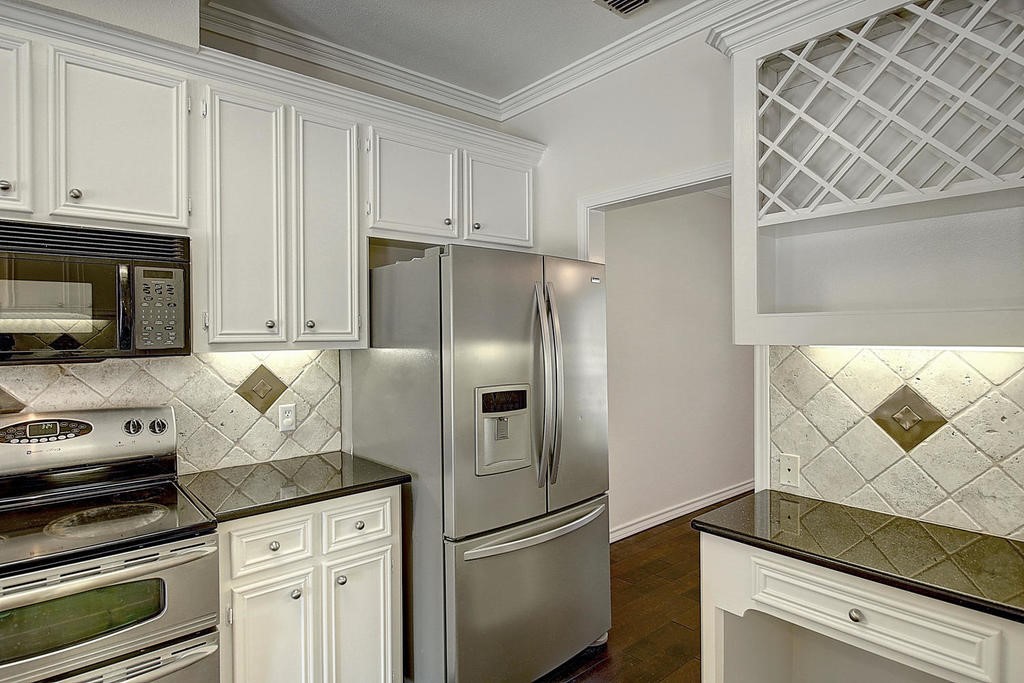 5101 Cavendish Drive Corpus Christi, TX 78413 - Photo 9 of 40 a kitchen with granite countertop a refrigerator stove and cabinets
