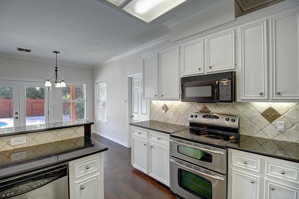 5101 Cavendish Drive Corpus Christi, TX 78413 - Photo 10 of 40 a kitchen with stainless steel appliances granite countertop a stove and a white cabinets