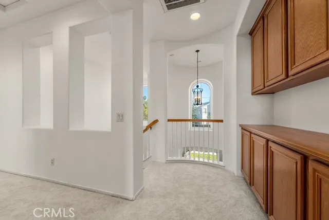 a view of a hallway with entryway wooden floor and cabinet