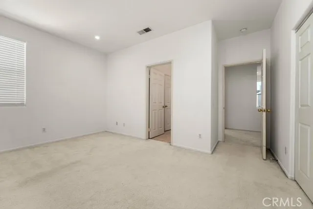 an empty room with closet and windows