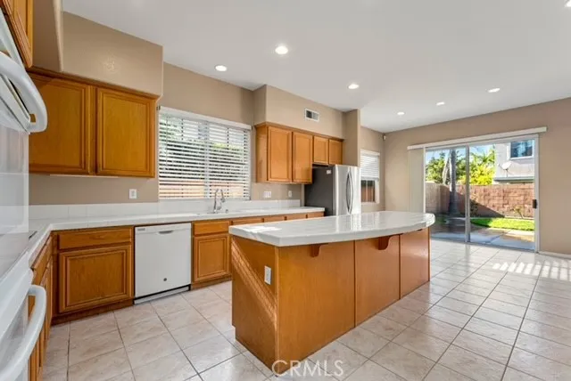 a kitchen with stainless steel appliances granite countertop a sink counter space cabinets and a large window