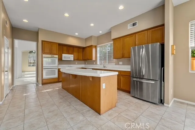 a kitchen with stainless steel appliances granite countertop a refrigerator and a stove top oven