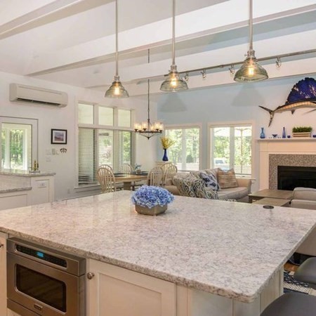 10 Codman Spring Road Edgartown, MA 02539 - Photo 13 of 32 a kitchen with a stove a sink dishwasher a dining table and chairs with wooden floor