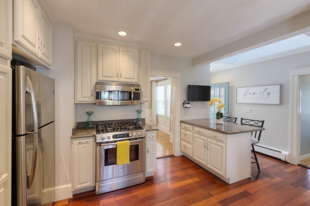46 Eagle Road Worcester, MA 01605 - Photo 11 of 42 a kitchen with stainless steel appliances granite countertop a stove top oven a refrigerator a sink and dishwasher with wooden floor