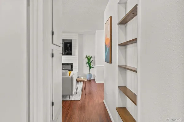 a view of a hallway with wooden floor and staircase