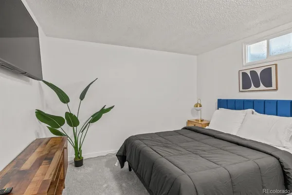 a bedroom with a bed and a potted plant