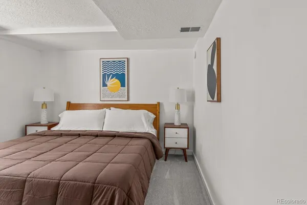 a bedroom with a bed and painting on the wall