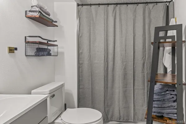 a white toilet sitting next to a shower curtain