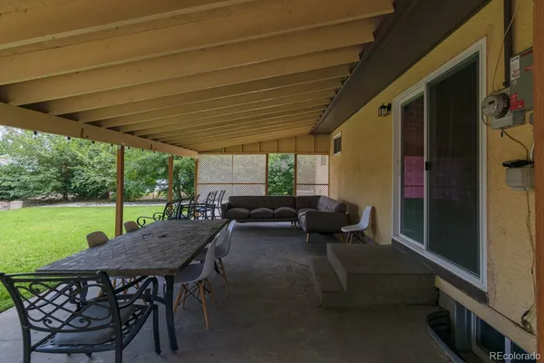 a view of a patio with table and chairs under an umbrella