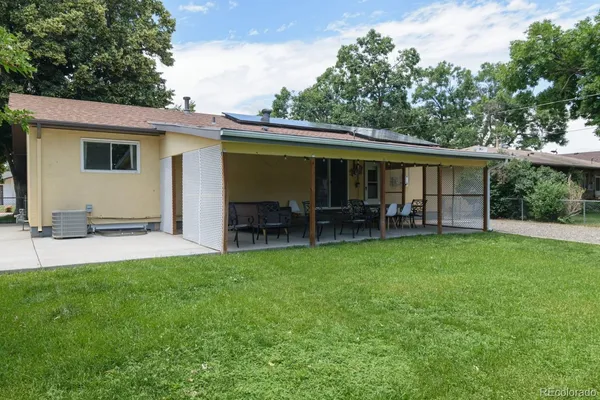 a view of a patio with table and chairs potted plants and large tree