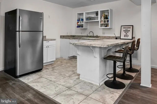 a kitchen with a sink a refrigerator and cabinets