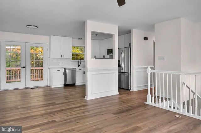 a view of a kitchen with a stove fridge and wooden floor