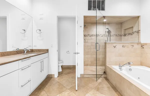 a bathroom with a granite countertop sink mirror and a bath tub