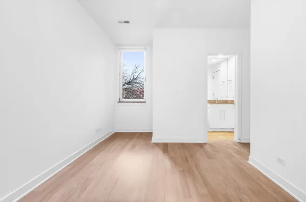 an empty room with wooden floor and door