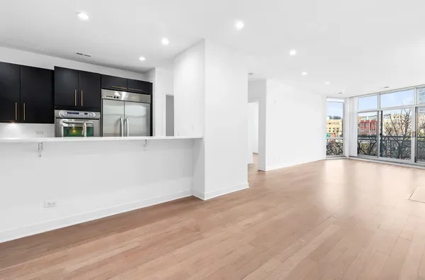 a view of kitchen with stainless steel appliances a refrigerator and wooden floor