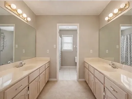 a bathroom with double sink and a large mirror