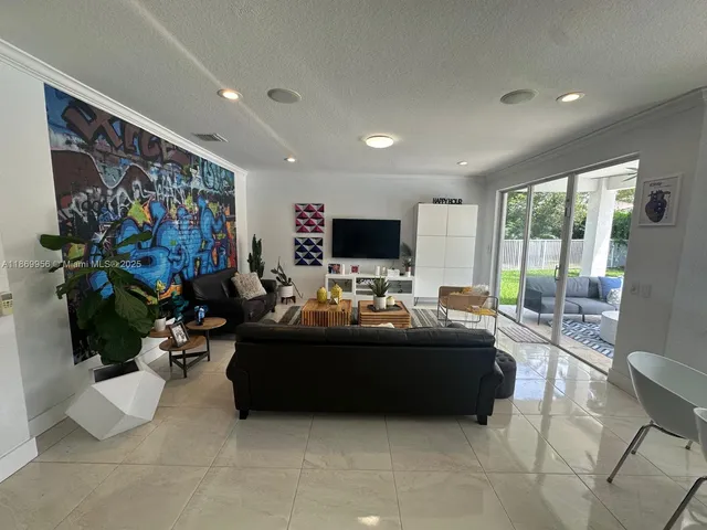 a living room with furniture and a floor to ceiling window
