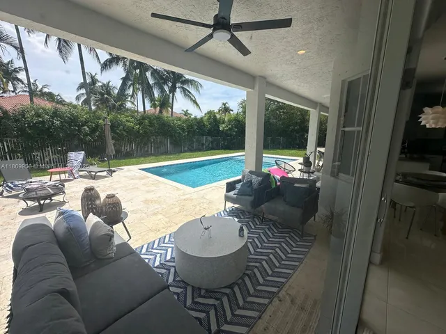 a view of a livingroom and a dining room and chandelier fan