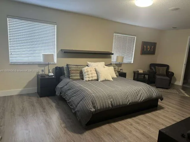 a large bedroom with a bed and wooden floor