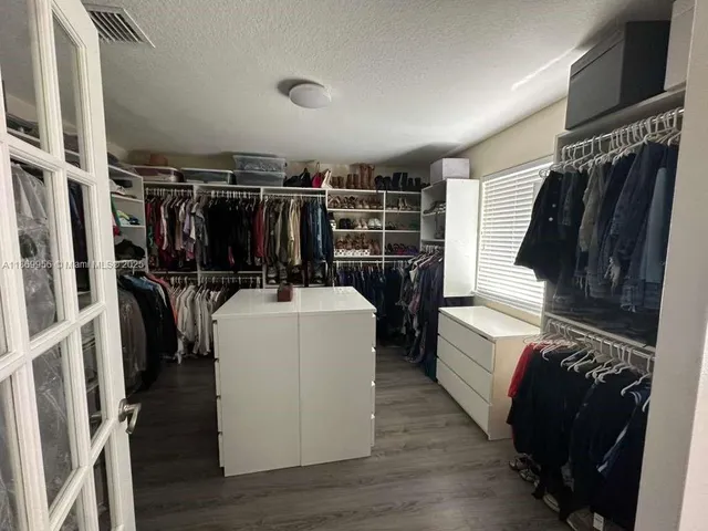 a view of walk in closet with clothes and shoes