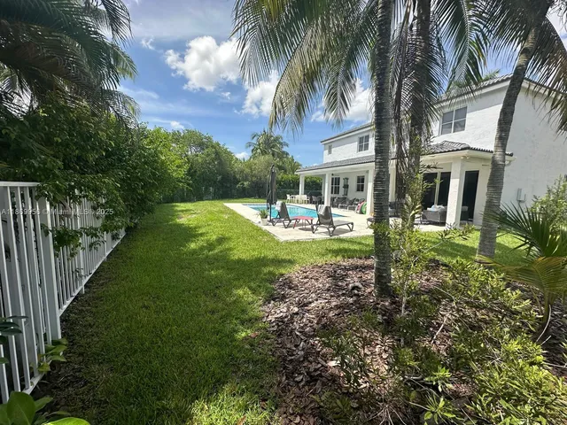a view of a house with a swimming pool and sitting area